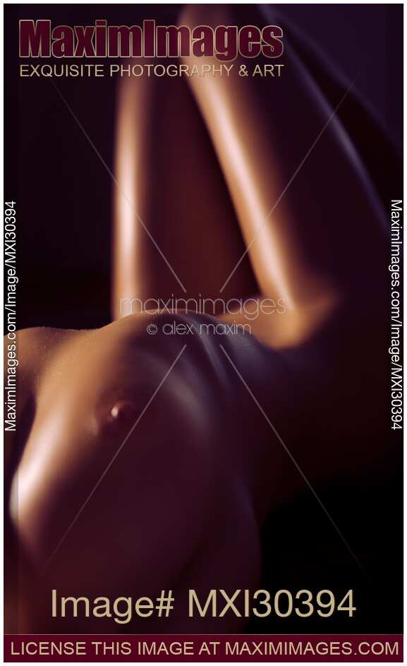 Abstract art nude photo of a sexy woman naked body closeup of breast and legs outline in dim light