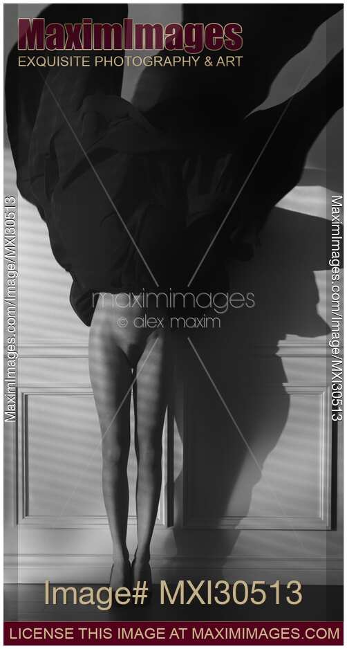 Abstract fine art nude black and white photo of a woman with her dress flying up revealing sexy bare legs