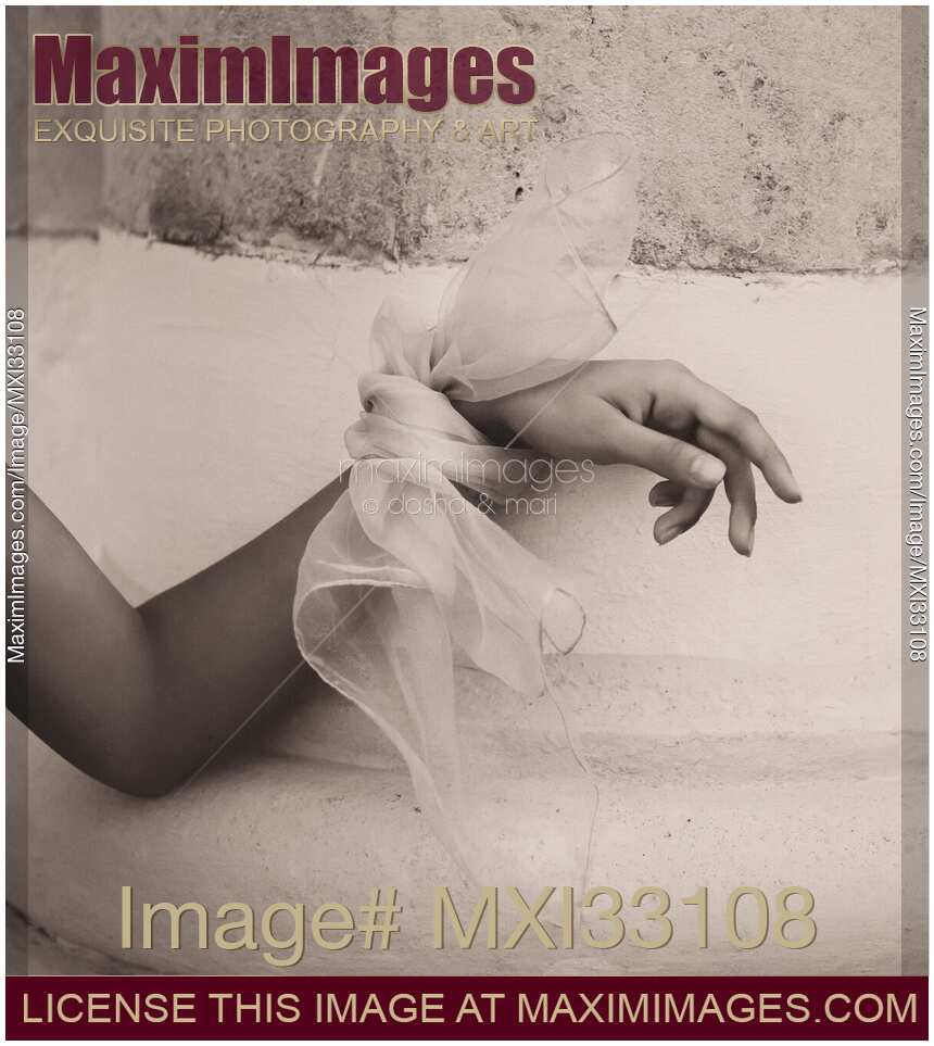 Abstract gentle female hand with a silk bow leaning against rustic old wall