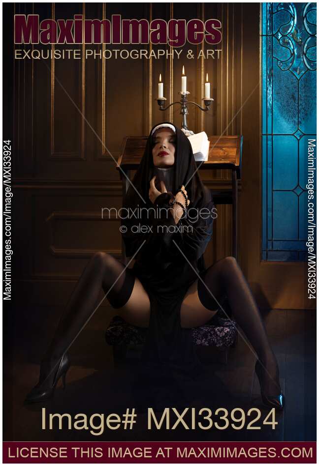 Adventurous holy sister sitting in a provocative suggestive pose with her legs in stockings spread wide apart on a prayer bench