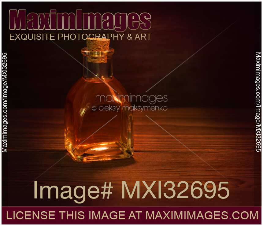 Antique glass bottle with a cork and amber liquid of extract or elixir Still life