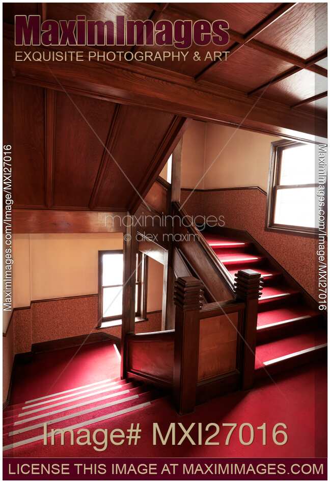 Antique wooden stairs with red carpet