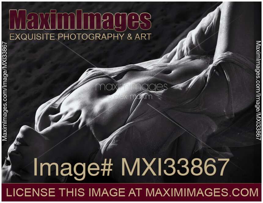 Art nude back and white, half-naked woman lying in sea water her naked sensual body barely covered with sheer clothes