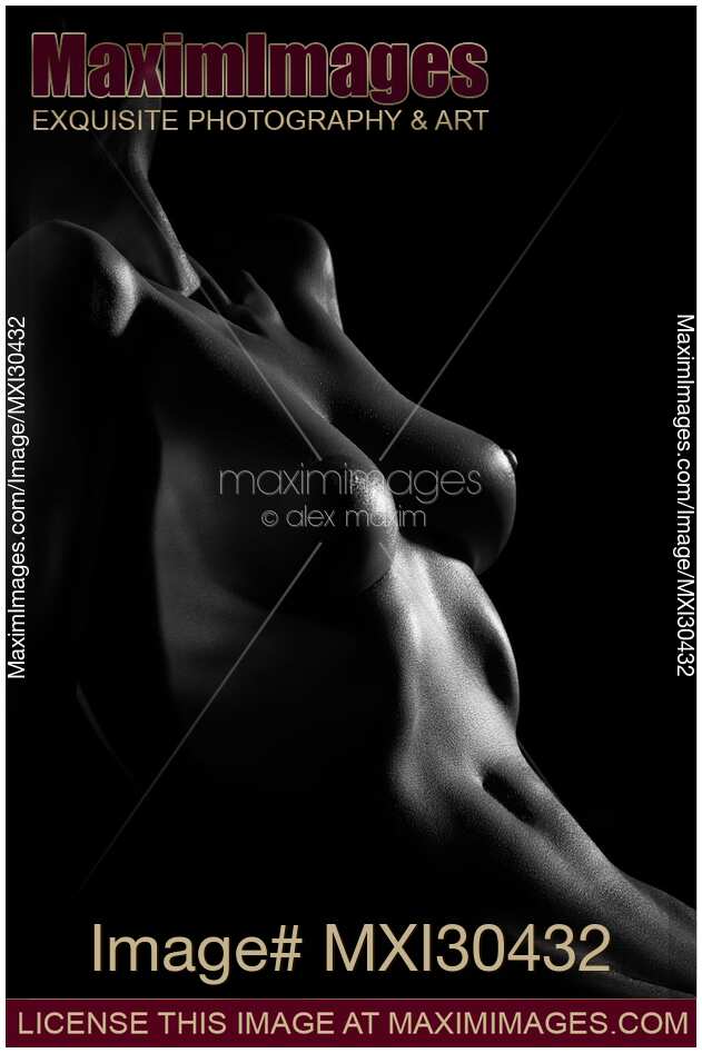 Art nude black and white closeup of a sexy woman body stomach and breast outline on black