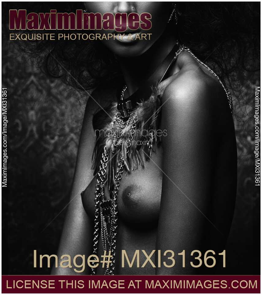Artistic black and white nude native woman breast with a feather necklace on her bare chest