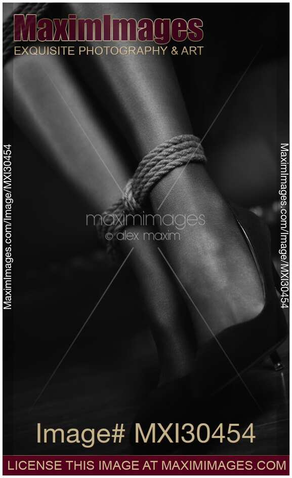 Artistic black and white of sexy woman ankles tied up with a bondage rope