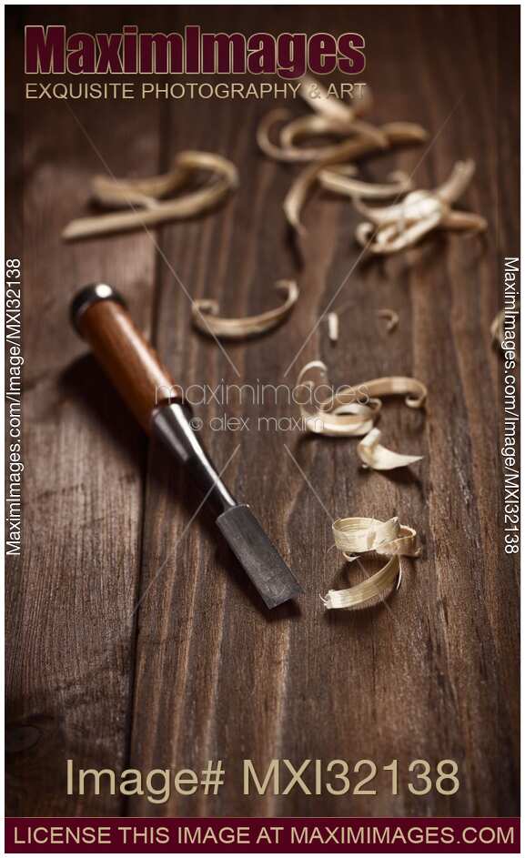 Artistic carpentry still life of a chisel and wood shavings on a table