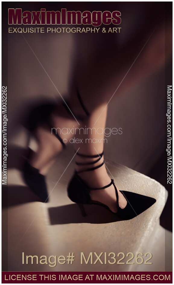 Artistic closeup of woman legs in sexy black high-heels walking down the staircase