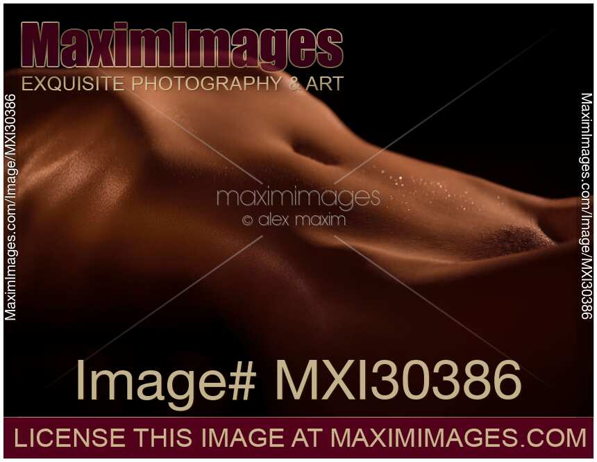 Artistic nude abstract body parts of a sexy woman stomach with shiny skin on black