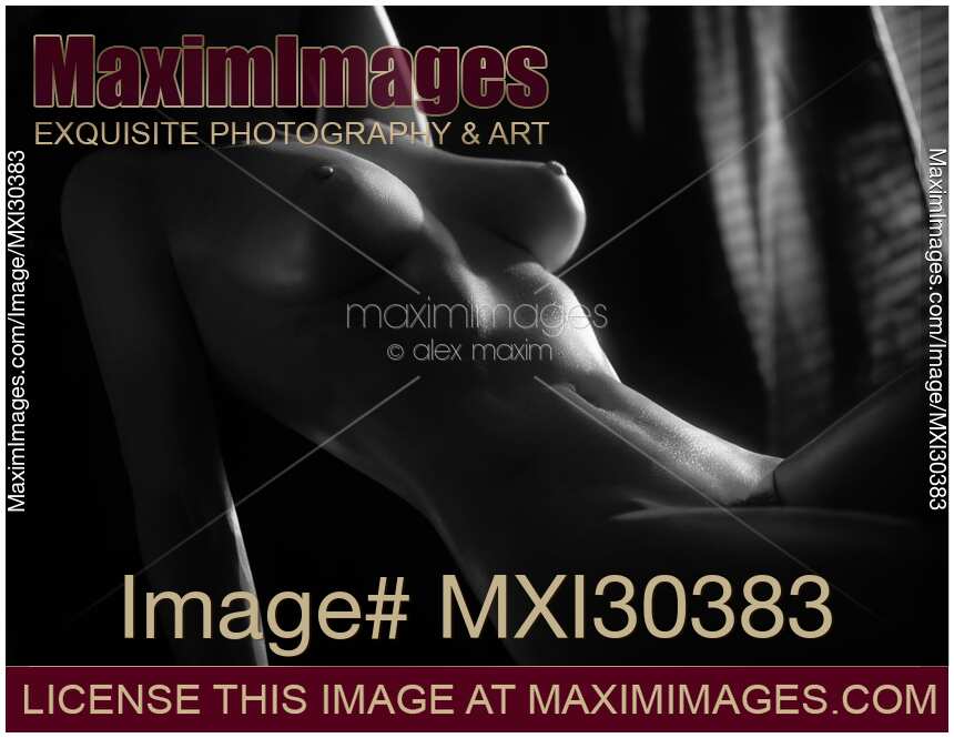 Artistic nude black and white photo of a woman slim sexy body in dim light coming from a window