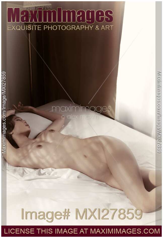 Artistic photo of a young woman sleeping naked in bed