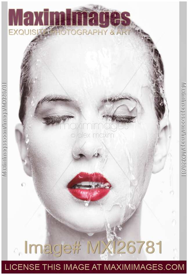 Artistic portrait of woman with red lipstick and water running over her face