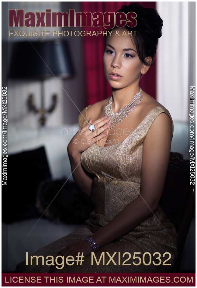 Artistic portrait of young woman sitting in dark bedroom