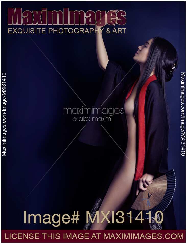 Artistic sensual portrait of a beautiful Asian woman with a hand fan wearing a black kimono partially revealing her nude body