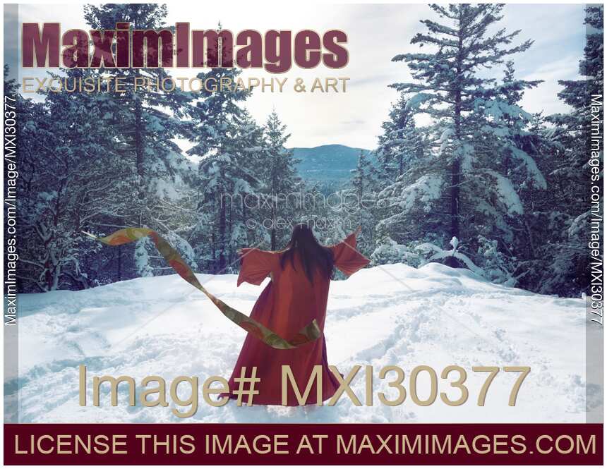 Asian woman in red kimono dancing on the snow in the forest