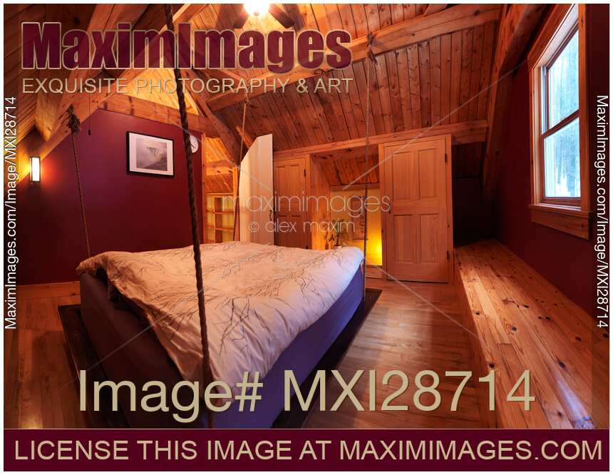 Attic loft bedroom with hanging bed in timber frame Canadian house
