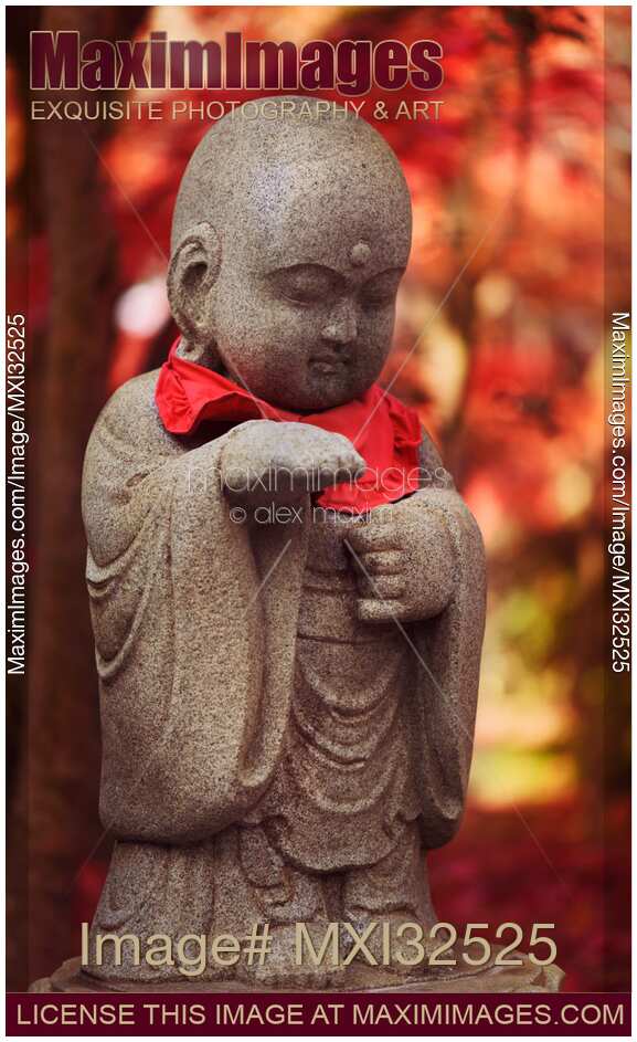 Baby Buddha cute stone statue in beautiful red autumn scenery