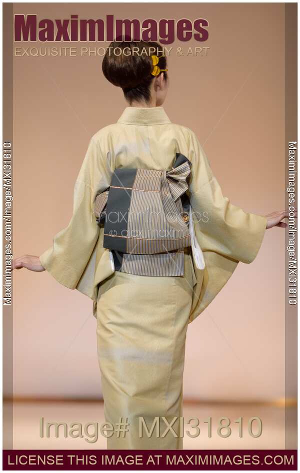 Back of a Japanese woman showing an obi belt of an elegant light green kimono