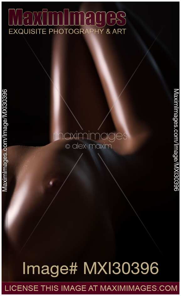 Beautiful art nude photo of a sexy woman body with dark oily skin in dim light closeup of breast and thighs outline