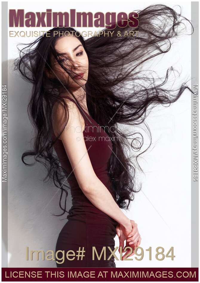 Beautiful asian woman with long flying in the wind black hair