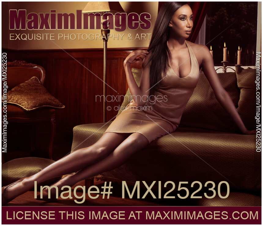 Beautiful black woman in sexy elegant mini dress sitting on a sofa Romantic glamour