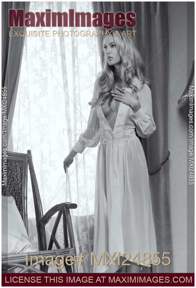 Beautiful blond woman in night gown by the window Black and white