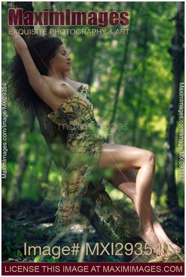 Beautiful half naked sexy young woman leaning against a tree in a forest sensual portrait