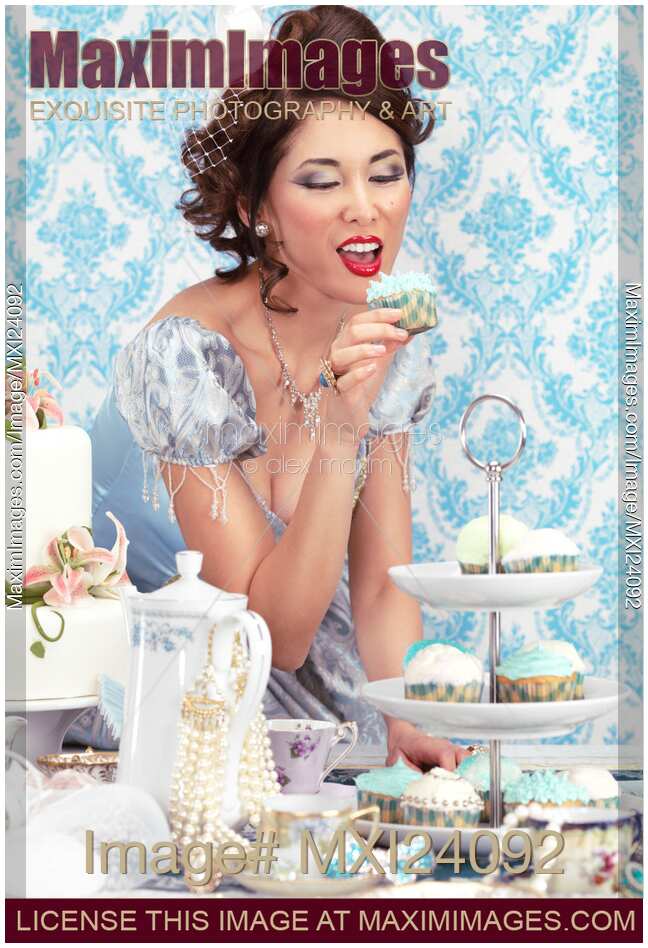 Beautiful lady is about to eat a cupcake at a tea party