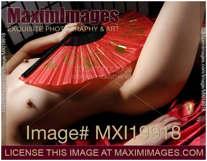 Beautiful naked asian woman covering her body with a red fan