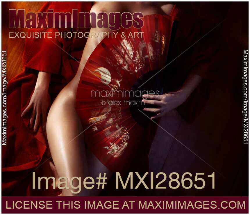 Beautiful naked woman body covered with red Asian fan