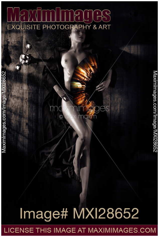 Beautiful naked woman covering her body with fan artistic nude Zen concept