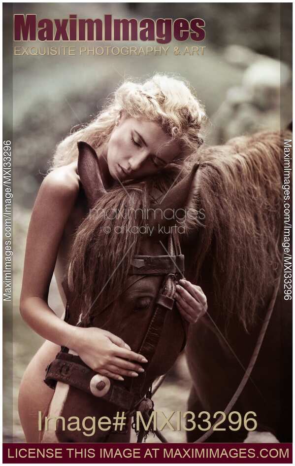 Beautiful naked woman with blond hair hugging a brown horse in the nature