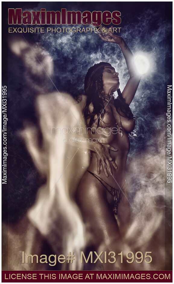 Beautiful nude tribal aboriginal woman performing ethnic ritualistic dance by the fire in full moon her naked body shining in dancing flames