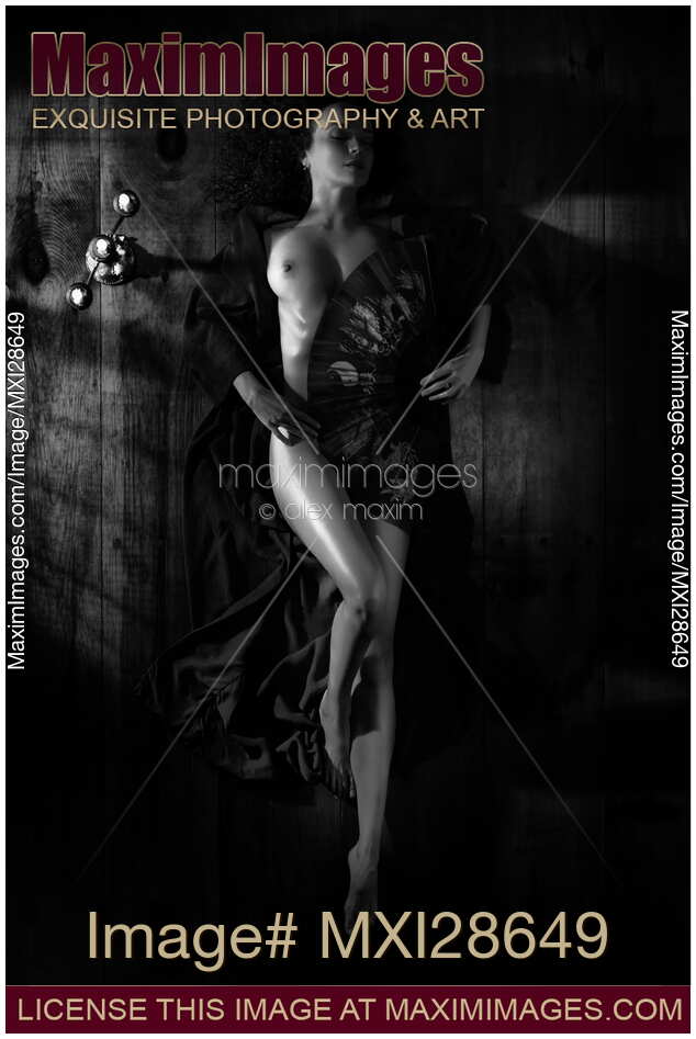 Beautiful nude woman covering her body with fan Black and white