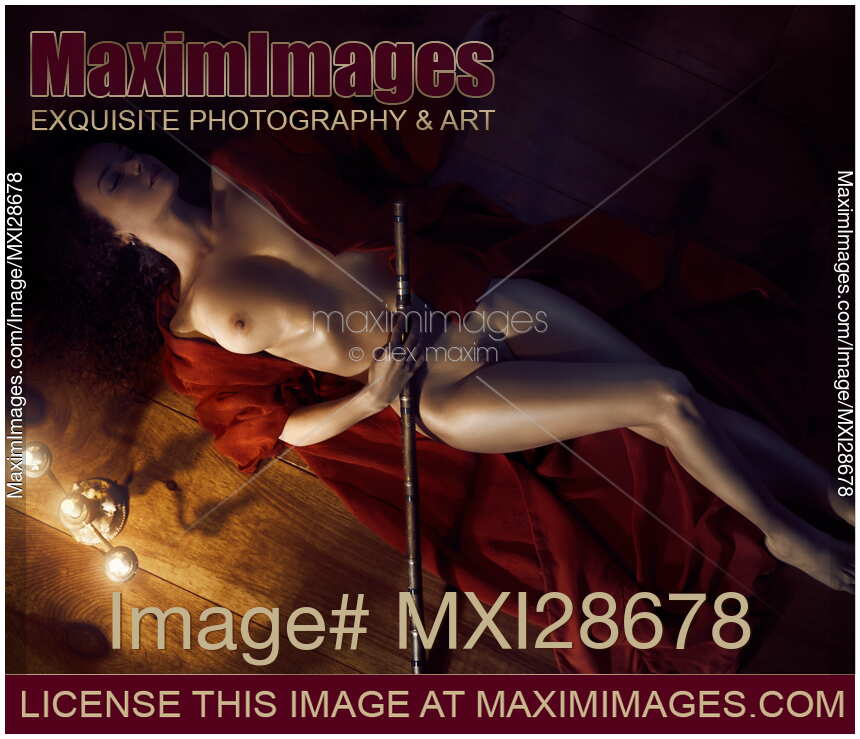 Beautiful nude woman in undone kimono lying in dim candle light