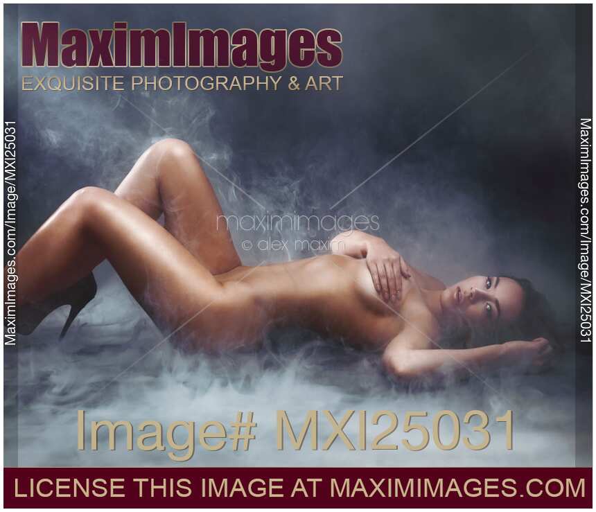 Beautiful nude woman lying in clouds of smoke