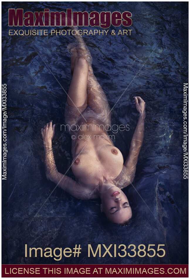 Beautiful nude woman lying in dark water relaxed with closed eyes view from above