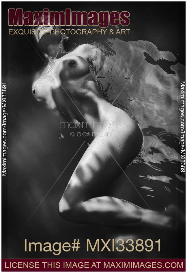 Beautiful nude woman lying in dark water with water droplets on her wet naked body Black and white