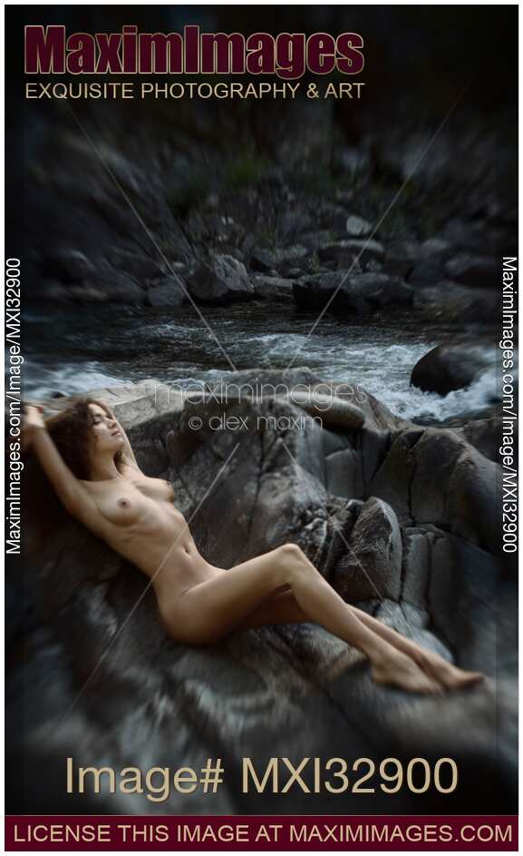Beautiful nude woman lying on rocks by a river in nature scenery Fine art nudes