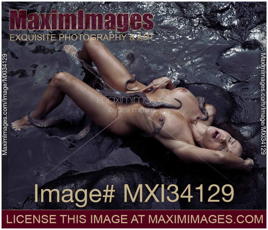 Beautiful nude woman making love to an octopus lying in dark sea water with his tentacles caressing her sexy naked body