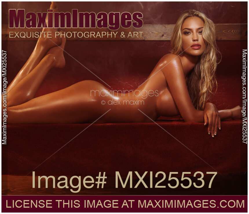 Beautiful nude woman with wet shiny sexy body lying naked in steam room or sauna
