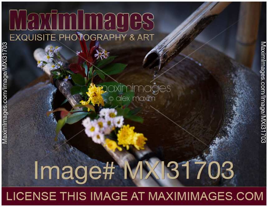Beautiful old water purification basin Tsukubai or hand bowl decorated with flowers in Takayama Japan