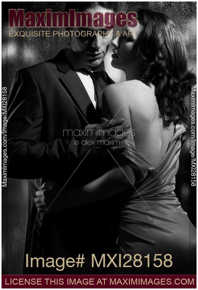 Beautiful portrait of couple standing near window on rainy night black and white