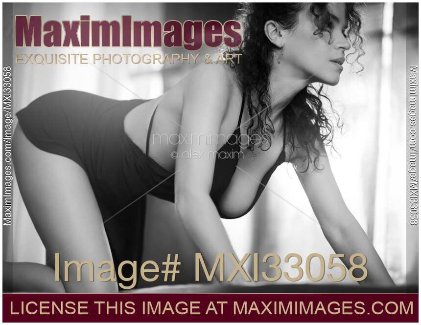 Beautiful seductive woman in a sensual prowling pose wearing a sexy dress Black and white