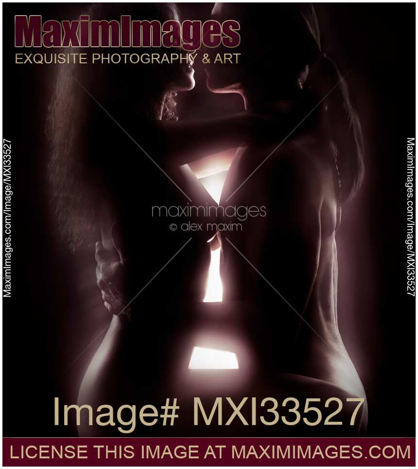 Beautiful sensual couple in an embrace with light glowing between their naked bodies. Tantric sexuality concept.