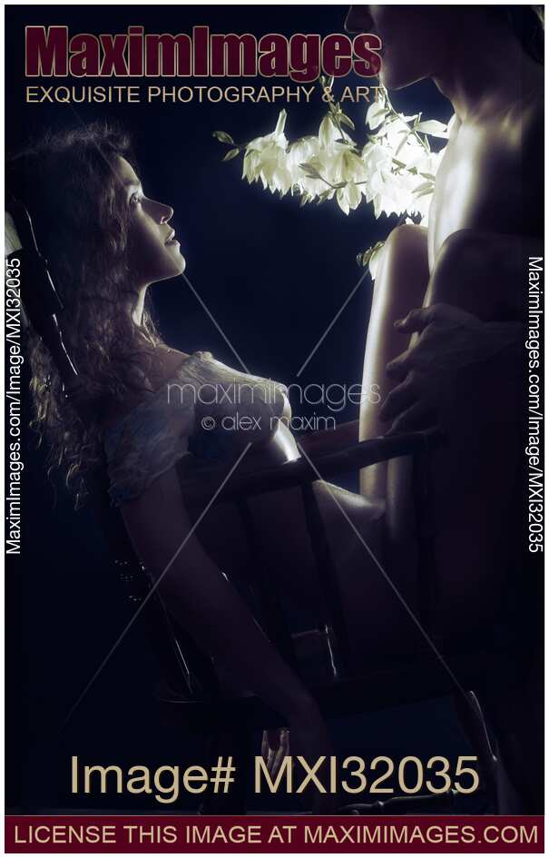 Beautiful sensual couple making love in a rocking chair Half-naked bodies silhouette and white flowers on black