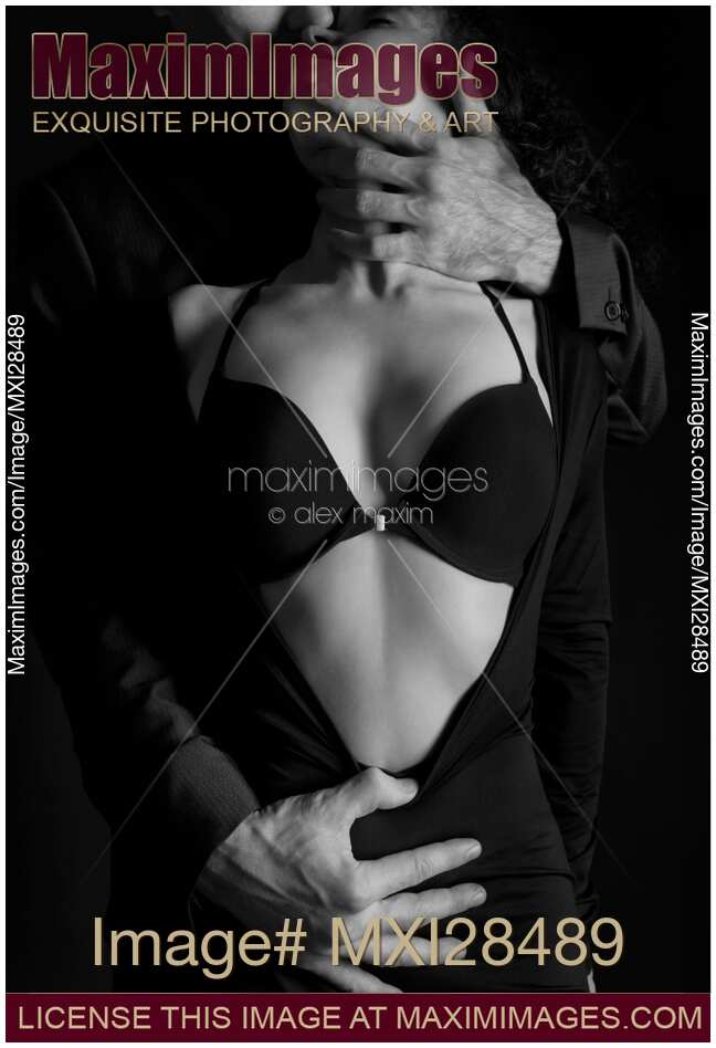 Beautiful sensual portrait of a couple. Man hands undressing a woman. Black and white