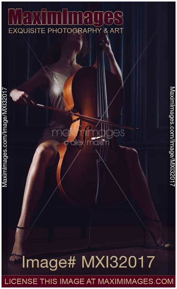 Beautiful sensual woman passionately playing cello in dim dramatic night time settings