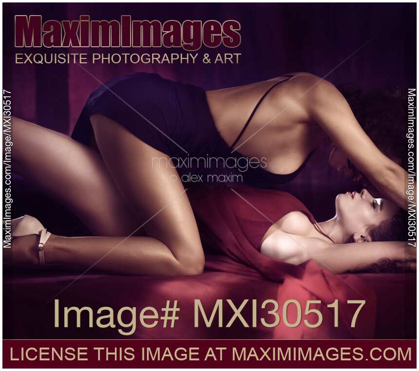 Beautiful sexy lesbian couple two women in dresses making love on a bed