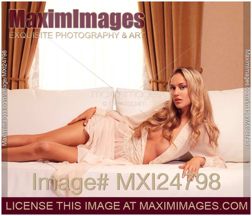 Beautiful sexy woman with blond hair lying on sofa